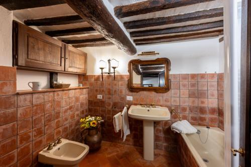 a bathroom with a sink and a toilet and a mirror at Artistica Pienza - Breathtaking Val d'Orcia View in Pienza