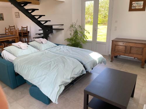 a bedroom with a bed and a table and a table sidx sidx sidx at Chez Mamisa, Calme & Nature in Pullay