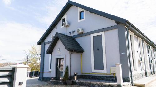 a white house with a black roof at Grey Boutique Hotel Palas in Iaşi