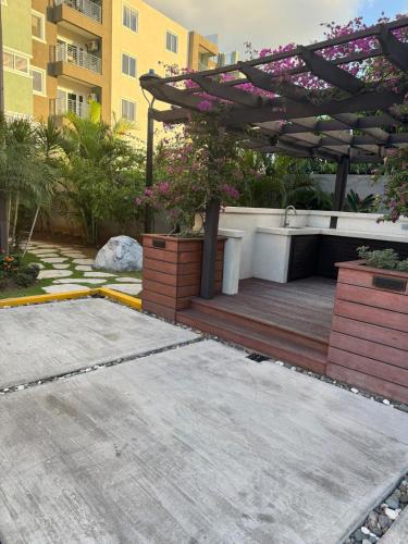 a patio with a pergola and a wooden deck at City Abode Kingston Jamaica in Kingston