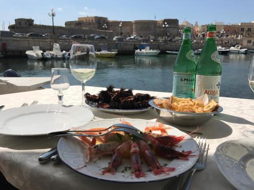 a table with two plates of food and two bottles of wine at Villa Eufemia in Parabita