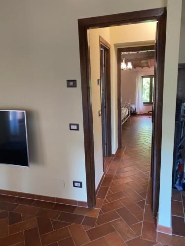 a hallway with a flat screen tv on a wall at Rosa di Maggio in Pari
