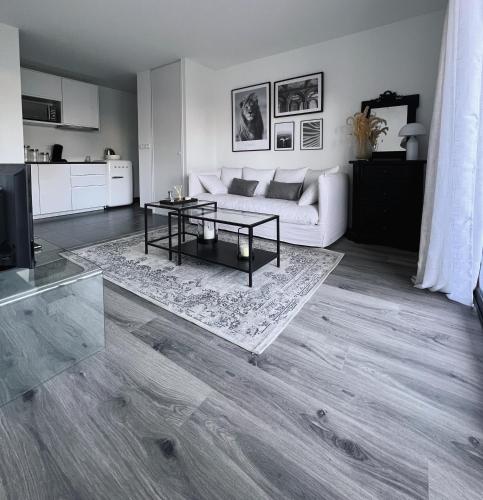 un salon avec un canapé blanc et une table dans l'établissement Sublime appart avec Jardin - 5 mn à pied des halles et plages, à Dinard