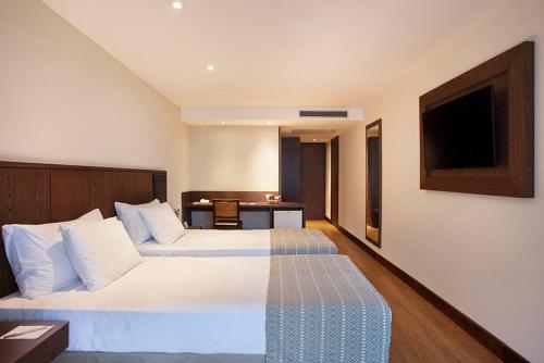 a hotel room with a bed and a table at Windsor Palace Copacabana in Rio de Janeiro