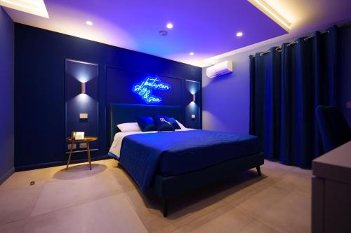 a blue bedroom with a bed with a neon sign at Heaven Room in Striano