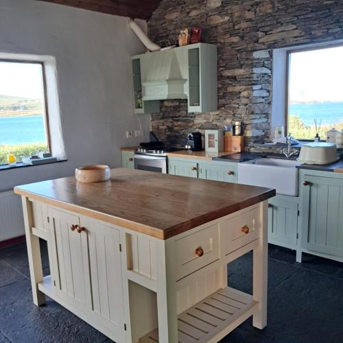 a kitchen with a wooden island in the middle at Old Stones Cottage in Portmagee