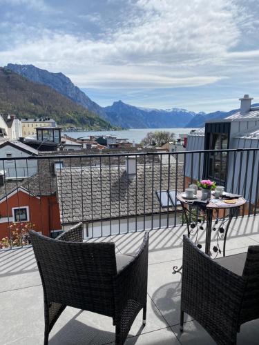 eine Terrasse mit zwei Stühlen und einem Tisch auf einem Balkon in der Unterkunft CityLake G23 Apartments mit kostenlosem Parkgaragen-Stellplatz !! in Gmunden