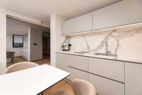 a kitchen with white cabinets and a table and chairs at Vida's Place in Malinska