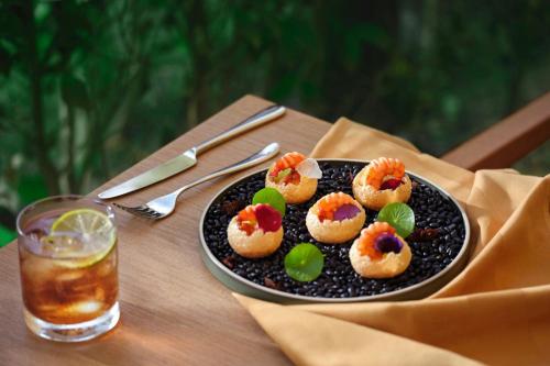 a plate of food on a table with a drink at The Westin Resort & Spa Cam Ranh in Cam Ranh