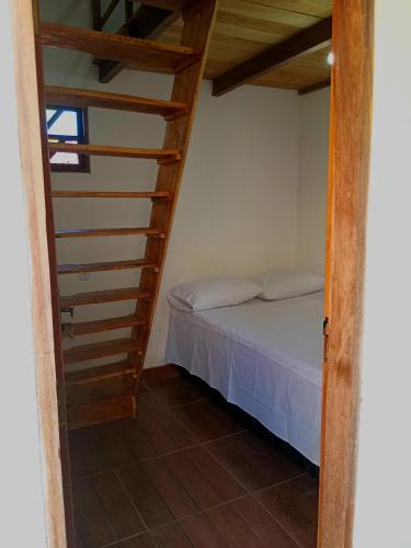 ein Schlafzimmer mit einem Bett und einer Treppe in der Unterkunft Quarto para 4 a 900 metros da Vila do Capão in Vale do Capao