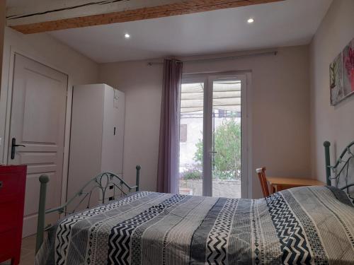 a bedroom with a bed and a refrigerator and a window at Jolie Studio plein pieds proche plage in Le Pradet
