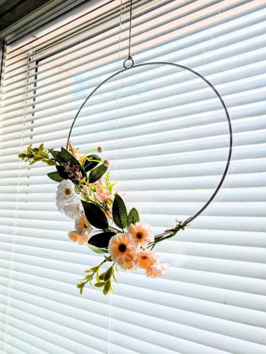 a flower wreath hanging in a hoop in a window at 20 - Nice apartment in Kemi City Centre, free parking! in Kemi