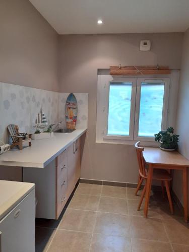 une cuisine avec une table, un évier et une fenêtre dans l'établissement Jolie Studio plein pieds proche plage, au Pradet