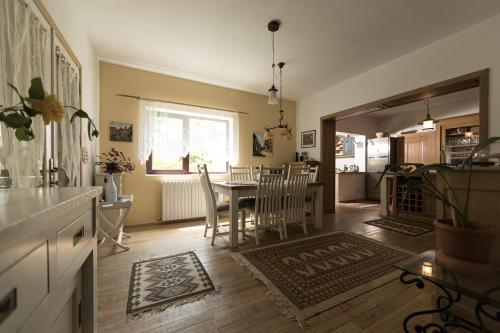 a kitchen and dining room with a table and chairs at Casa Mariei - Vila Breaza in Nistoreşti