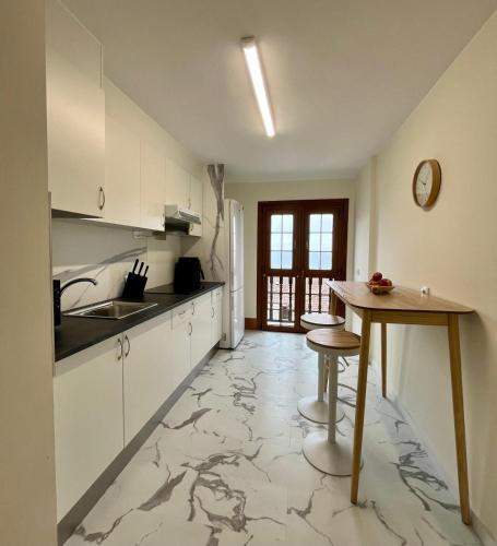 a kitchen with a marble floor and a table at Otto's Home Horizonte in Lastres