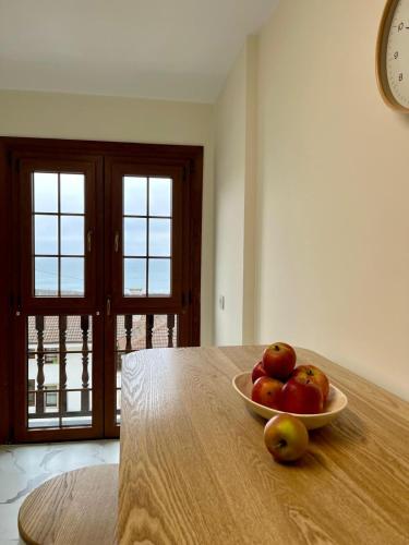 a bowl of apples sitting on top of a table at Otto's Home Horizonte in Lastres