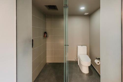 a bathroom with a toilet and a glass shower stall at Lettera Hotel in Medellín