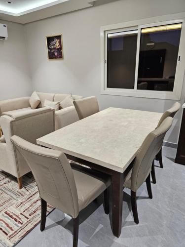 a dining room with a table and chairs and a couch at اجيال المدينة للشقق المخدومة - Ajyal Al-Madina Serviced Apartments in Al Madinah