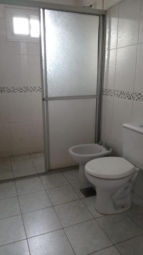 une salle de bain avec toilettes et cabine de douche dans l'établissement Hostel La Bodega, à Encarnación