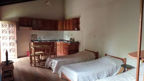 une cuisine avec deux lits et une table dans une chambre dans l'établissement Hostel La Bodega, à Encarnación