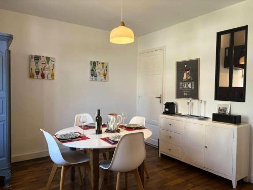 une salle à manger avec une table et des chaises blanches dans l'établissement Résidence C03-perros Guirec - Maison de charme Côte de Granit Rose Perros Guirec MAE-0951, à Perros-Guirec