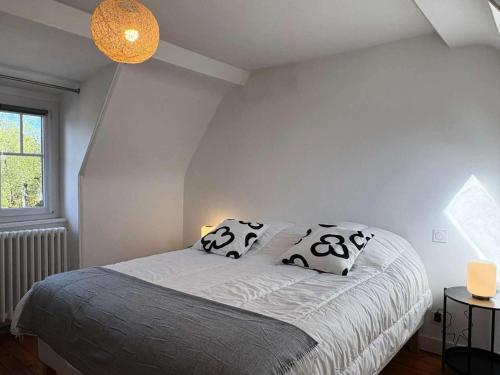 une chambre avec un lit avec deux oreillers dessus dans l'établissement Résidence C03-perros Guirec - Maison de charme Côte de Granit Rose Perros Guirec MAE-0951, à Perros-Guirec