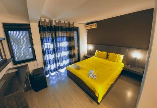 a bedroom with a yellow bed with two pairs of shoes on it at White Lake Apartments City Center Ohrid,Lakeside in Ohrid