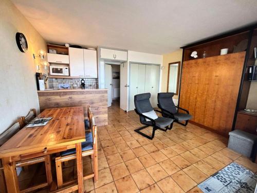 un salon avec une table et des chaises en bois dans l'établissement Résidence Cote D'argent - Arcachon studio cabine les pieds dans l'eau MAE-9434, à Arcachon