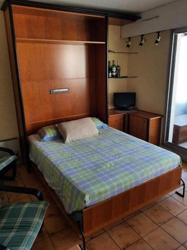 une chambre avec un grand lit avec une tête de lit en bois dans l'établissement Résidence Cote D'argent - Arcachon studio cabine les pieds dans l'eau MAE-9434, à Arcachon