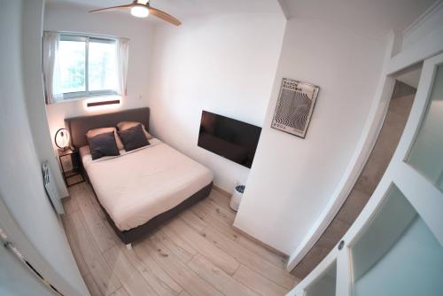 une petite chambre avec un lit et une télévision à écran plat dans l'établissement Au coeur de Marina baie des anges, à Villeneuve-Loubet