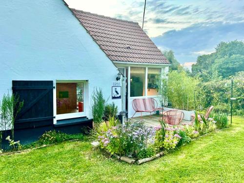 une petite maison bleue avec deux chaises sur une terrasse dans l'établissement Le Cocoon de la Héronnière, à Houlle