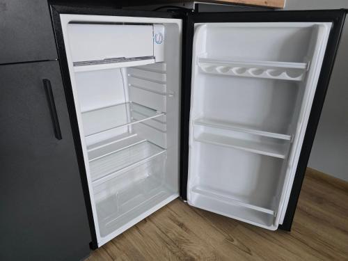 MrowinoにあるCOBBY noclegi Mrowinoの部屋の中にドアが開いたままの空の冷蔵庫
