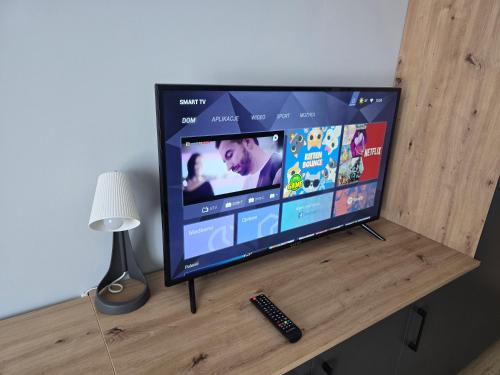 MrowinoにあるCOBBY noclegi Mrowinoの木製テーブル(リモコン付)の薄型テレビ
