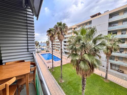 a balcony with a view of a pool and palm trees at Apt compartido martirrena in Badalona