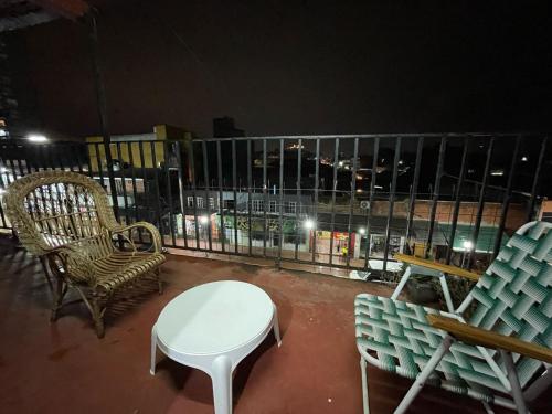 a table and chairs on a balcony at night at Green Vibes Iguazú A pasos de Av Brasil con WiFi, AA y Parrilla in Puerto Iguazú