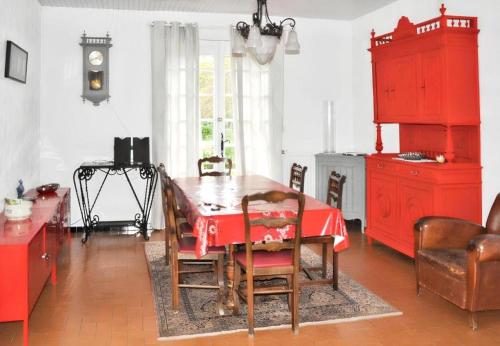 une salle à manger avec une table et des armoires rouges dans l'établissement Résidence 068-le Verdon Sur Mer - 068 - Maison familiale avec jardin au Verdon-sur-Mer MAE-4361, au Le Verdon-sur-Mer