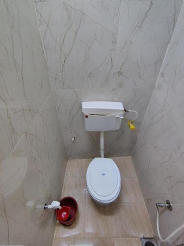 a bathroom with a white toilet in a room at aaram ac dormitory in Ahmedabad