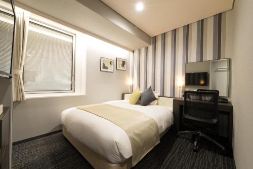 a hotel room with a bed and a desk and a television at Hotel Granvia Osaka-JR Hotel Group in Osaka