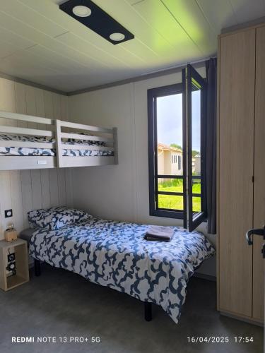 une chambre avec deux lits et une fenêtre dans l'établissement cottage Landes entre terre et ocean, à Saubrigues
