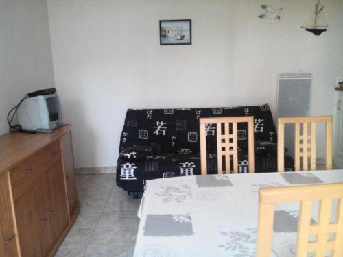 une salle à manger avec une table et un canapé avec une couverture dans l'établissement Résidence Villa Helios - SAINT MARC SUR MER 2 pièces centre-ville MAE-6281, à Géraud