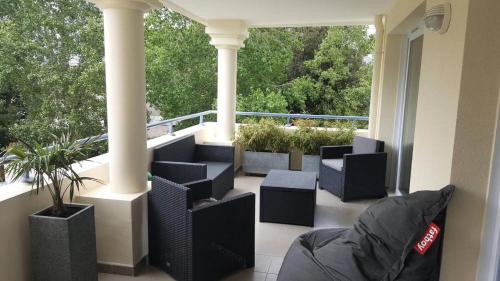 d'un balcon avec des chaises noires et une grande fenêtre. dans l'établissement Résidence Royal Park - LA BAULE - ROYAL PARK MAE-7591, à Mazy