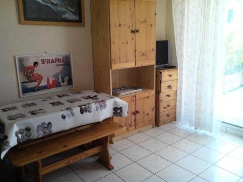 Cette chambre comprend une armoire en bois et une table. dans l'établissement Résidence Alizée A - SAINT MARC SUR MER résidence Alizée 2 pièces cabine MAE-7611, à Géraud