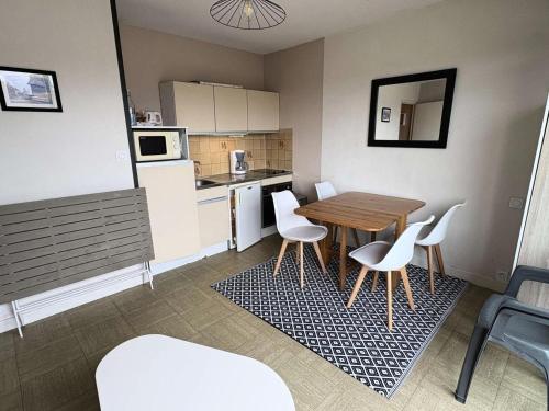 - une petite cuisine avec une table et des chaises blanches dans l'établissement Résidence Le Renaissance - Pornichet - Studio Place du Marché MAE-6571, à Pornichet