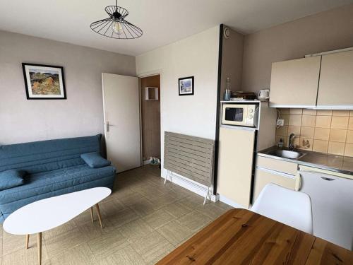 un salon avec un canapé bleu et une cuisine dans l'établissement Résidence Le Renaissance - Pornichet - Studio Place du Marché MAE-6571, à Pornichet