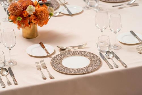 a table with plates and silverware and a vase of flowers at Bulgari Hotel Shanghai in Shanghai