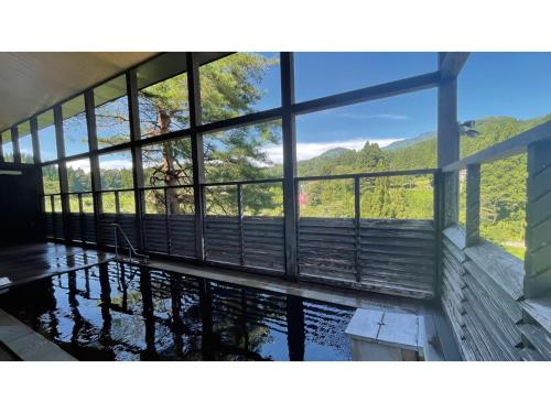 a room with a pool of water with a large window at TAKAYANAGI JONNOBI VILLAGE - Vacation STAY 72812v in Kashiwazaki