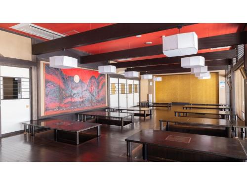 a room with tables and a painting on the wall at TAKAYANAGI JONNOBI VILLAGE - Vacation STAY 72812v in Kashiwazaki
