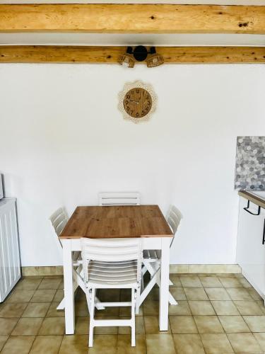 - une table et des chaises dans une cuisine dotée d'un plafond en bois dans l'établissement Anisades, Maison cosy avec jardin 5 min plage, au Barcarès