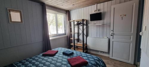 a bedroom with a bed with red pillows and a window at Aux Passagers de la Baie in Le Crotoy