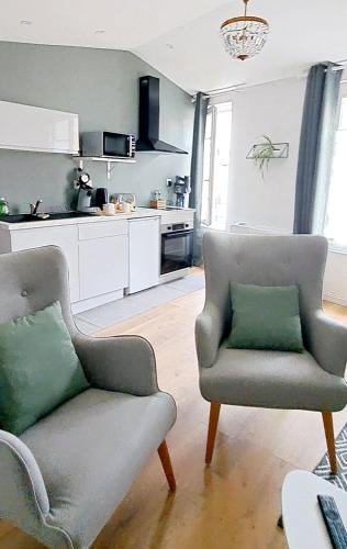 un salon avec un canapé et une chaise dans l'établissement La porte Bleue - appartement juste rénové - très propre - grand confort - lumineux - calme - centre historique, à Niort